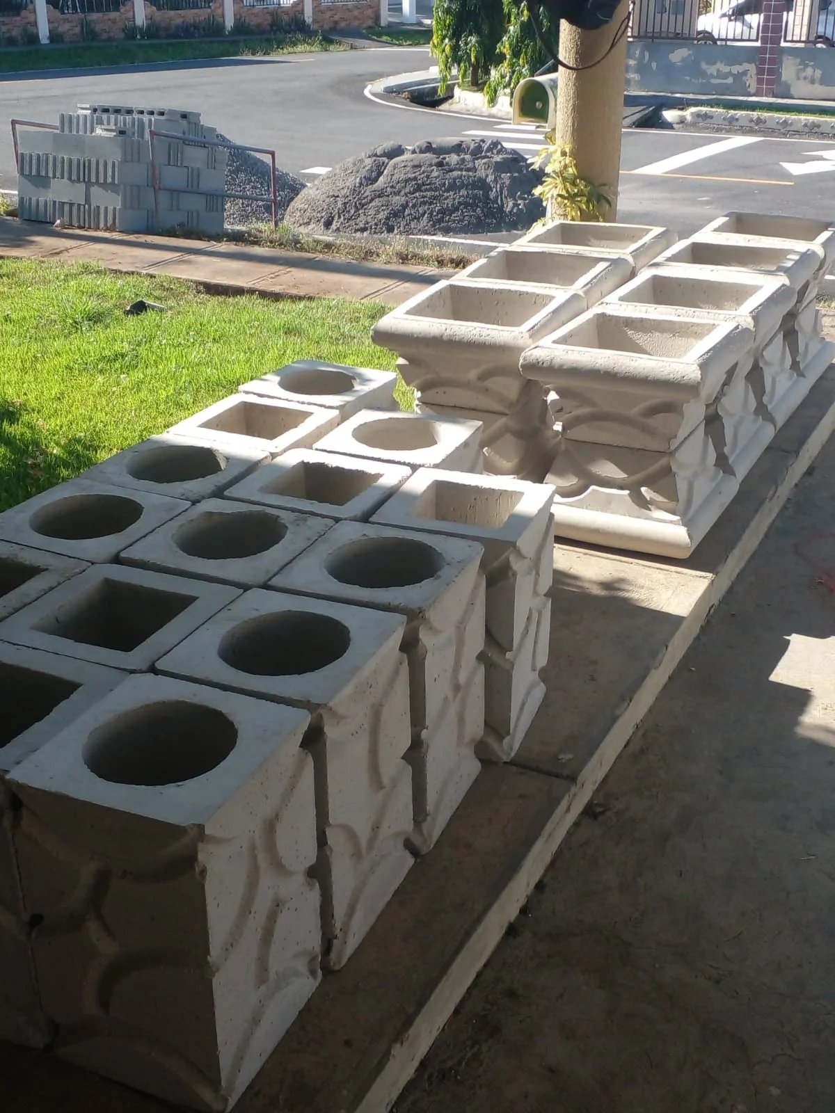 Bloques decorativos prefabricados con forma cuadrada y maceteros de concreto recién fabricados
