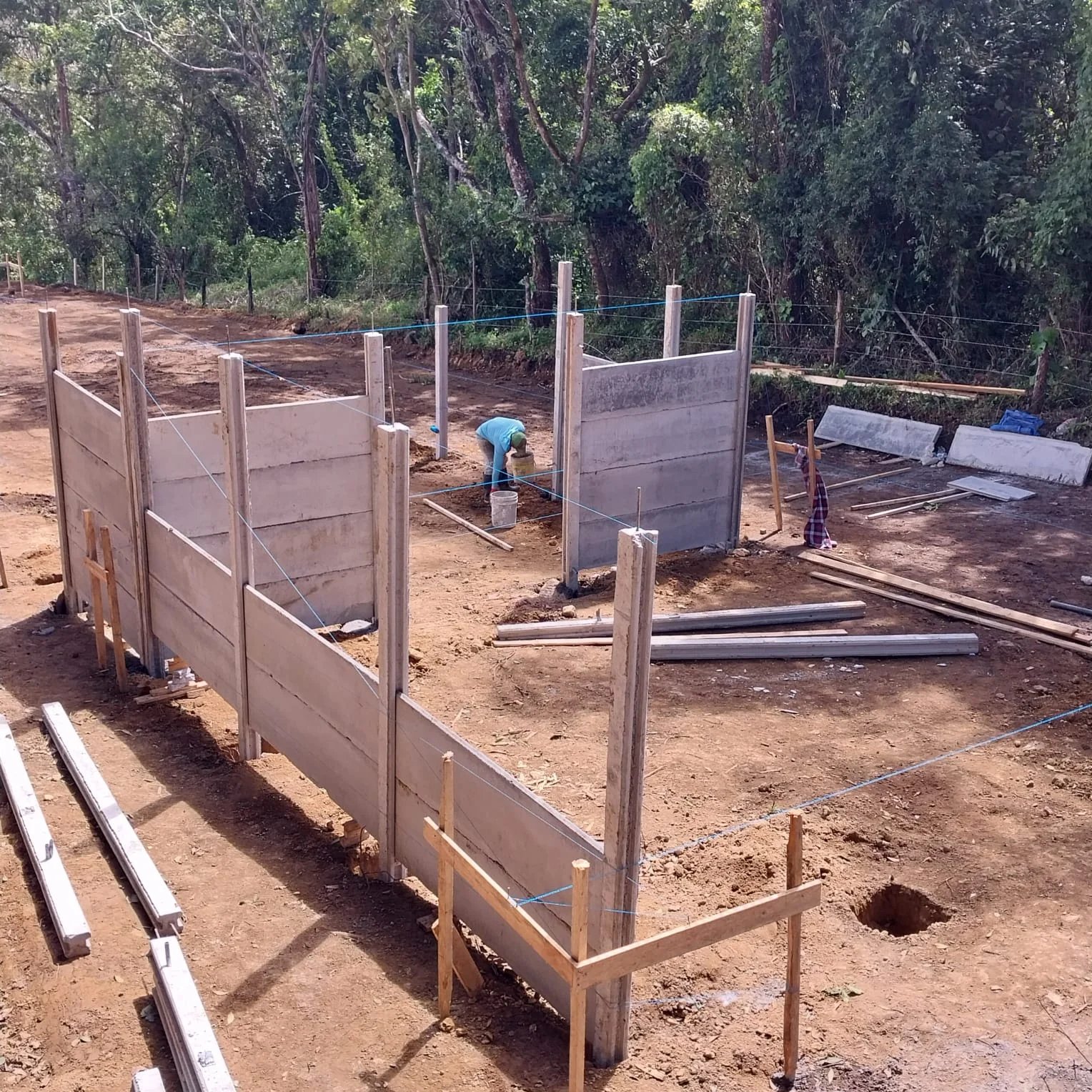 Estructura inicial de casa prefabricada con columnas verticales nuevas en lote en preparación