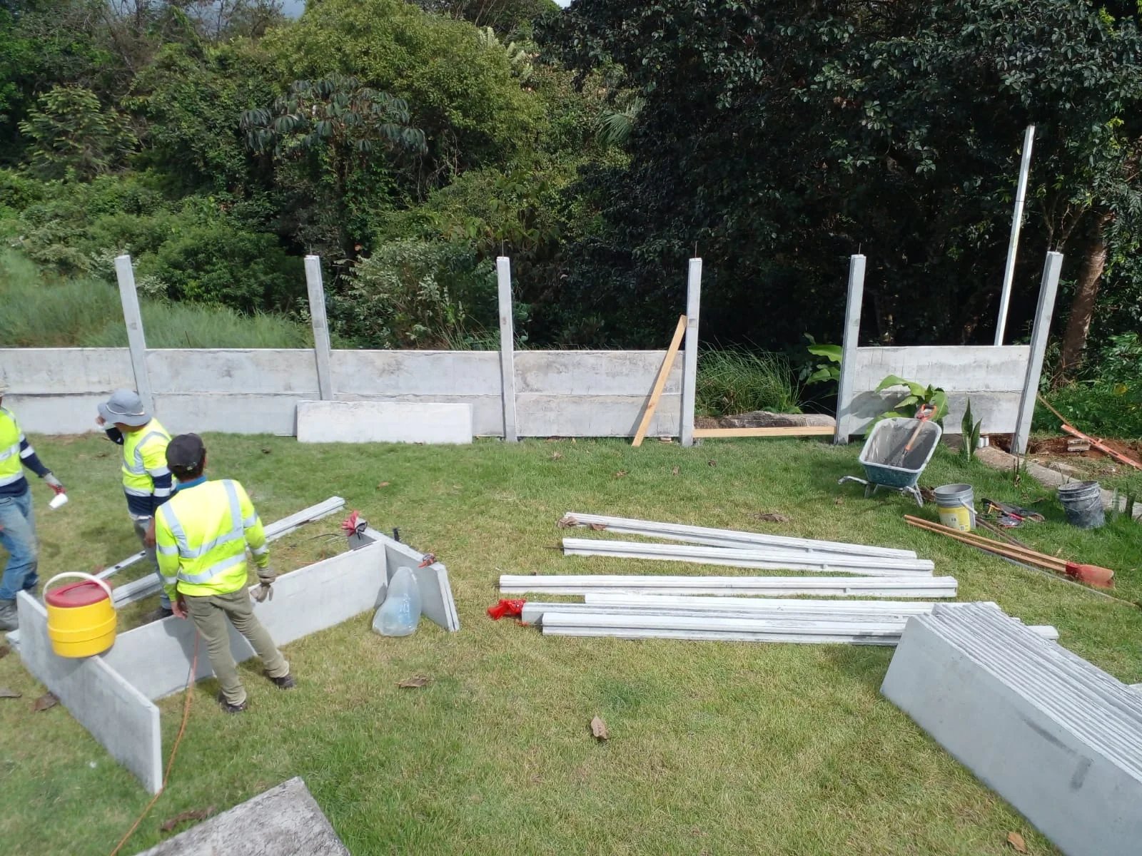 Cuadrilla instalando columnas y bases de muro perimetral prefabricado en obra residencial