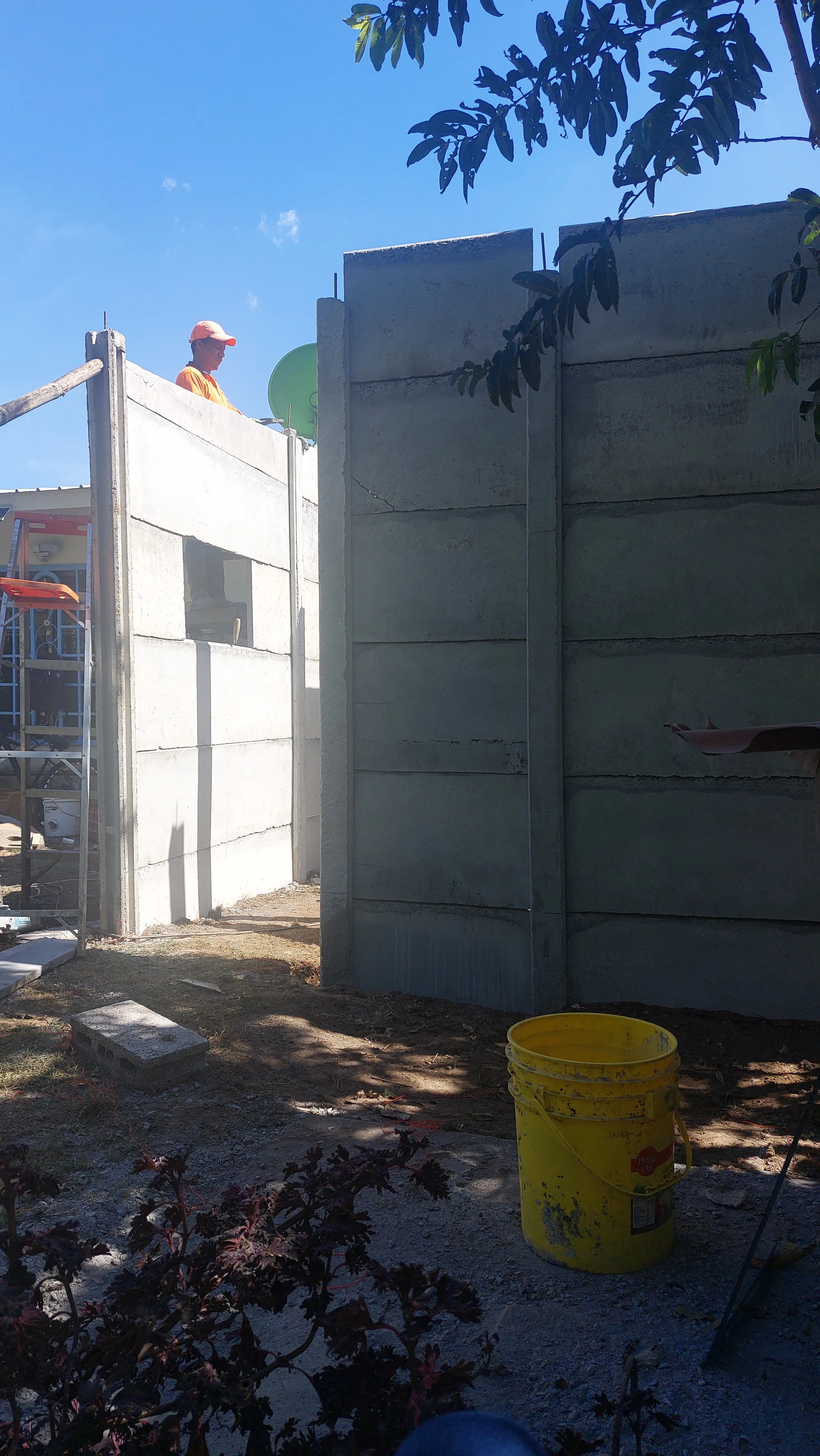 Operario con casco instalando paneles prefabricados verticales en casa prefabricada en construcción